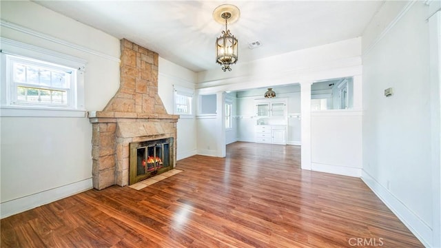 unfurnished living room featuring wood finished floors, a fireplace, and baseboards