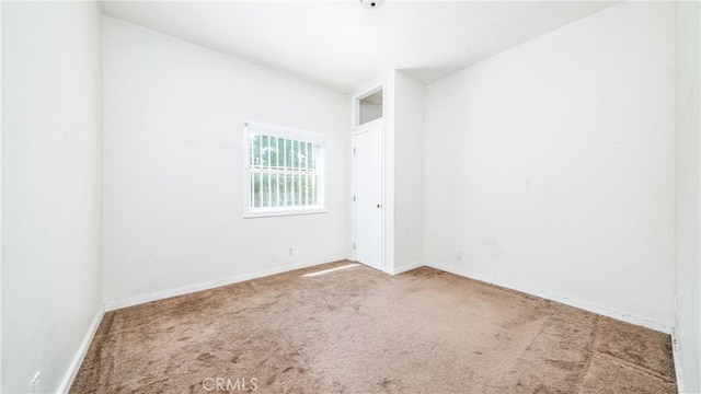 unfurnished room with carpet and baseboards