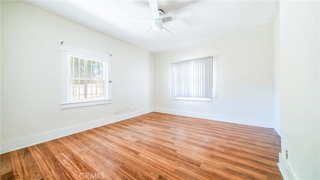 unfurnished room with light wood finished floors, baseboards, and ceiling fan