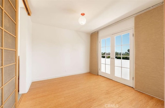 unfurnished room featuring wood finished floors and french doors