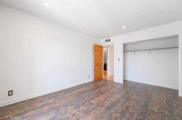 unfurnished bedroom with wood finished floors, recessed lighting, a closet, and baseboards