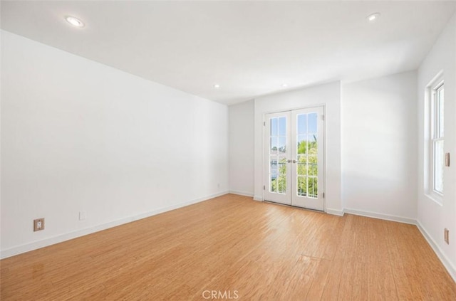 spare room with healthy amount of natural light, light wood-style floors, recessed lighting, and baseboards