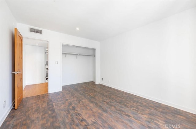 unfurnished bedroom with wood finished floors, a closet, recessed lighting, and baseboards