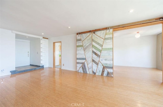empty room featuring wood finished floors, recessed lighting, and baseboards