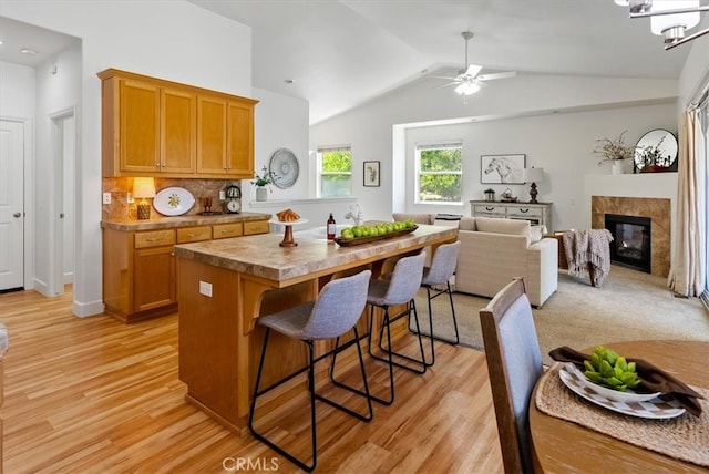 511 3rd St, Paso Robles, CA 93446 - kitchen featuring light wood-style flooring, a breakfast bar area, vaulted ceiling, ceiling fan, and a kitchen island