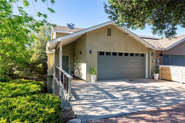 511 3rd St, Paso Robles, CA 93446 - view of property exterior with a garage, stucco siding, concrete driveway, and solar panels