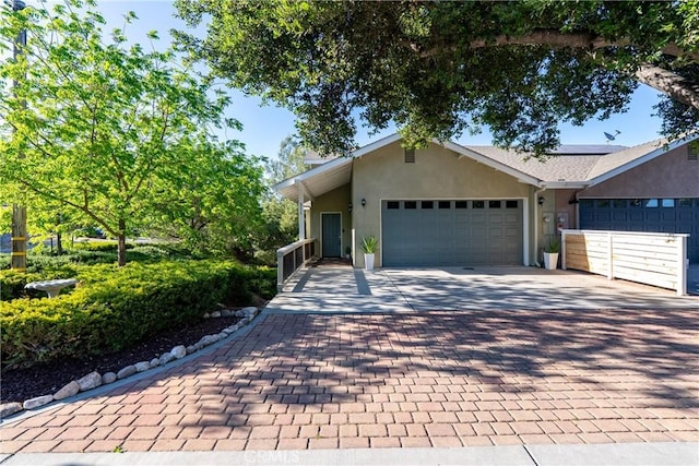 511 3rd St, Paso Robles, CA 93446 - view of front of property featuring stucco siding, decorative driveway, a garage, and solar panels
