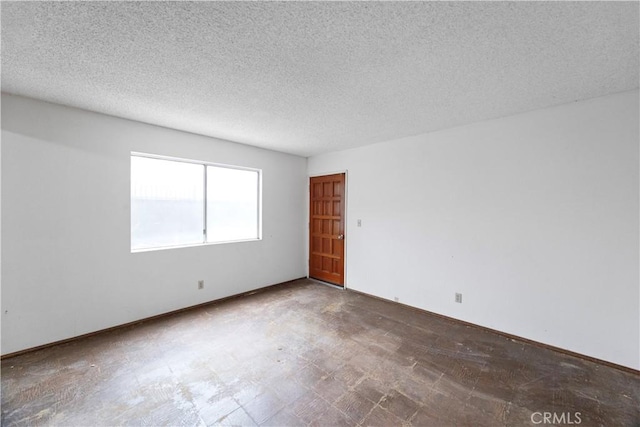 spare room with tile patterned floors and a textured ceiling