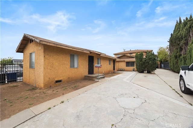 ranch-style house with fence and stucco siding