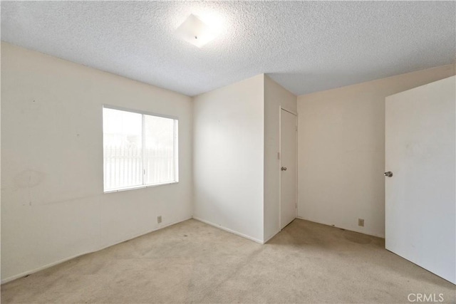 carpeted empty room featuring a textured ceiling