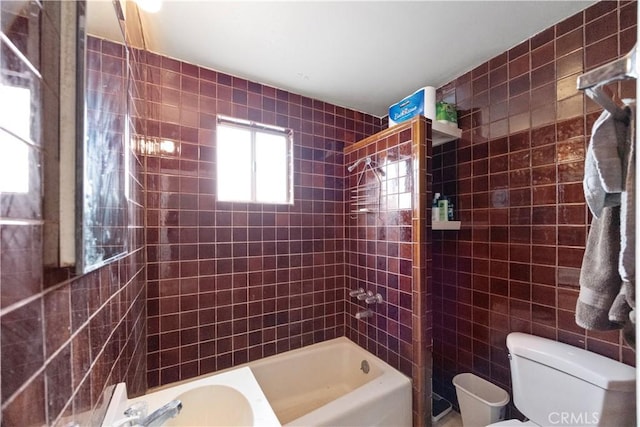 bathroom featuring toilet, tile walls, and shower / bathtub combination