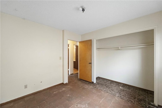 unfurnished bedroom featuring a closet and baseboards