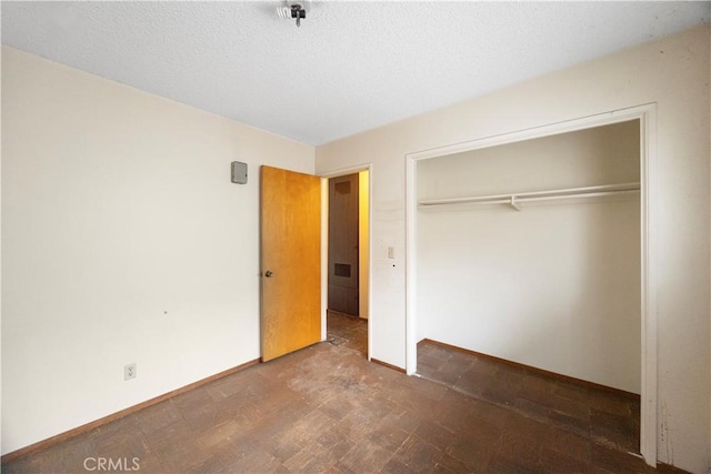 unfurnished bedroom with a closet and baseboards