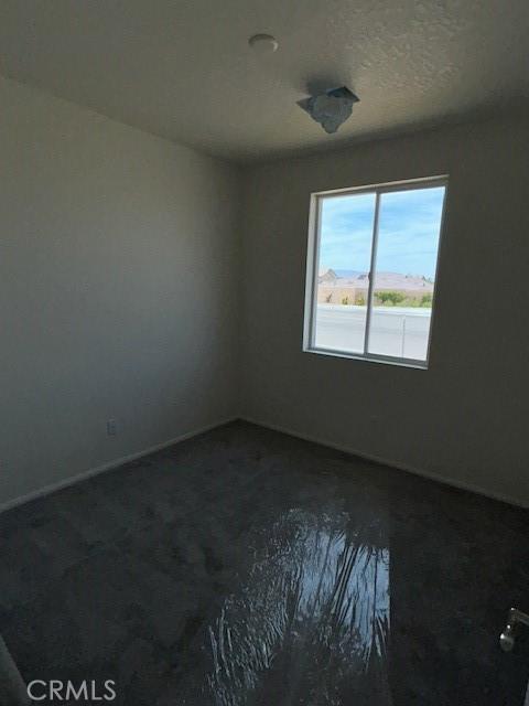 unfurnished room with baseboards
