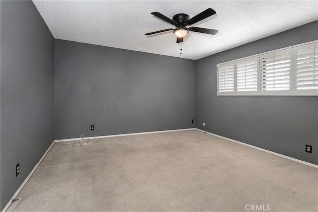 spare room featuring ceiling fan, carpet, baseboards, and a textured ceiling