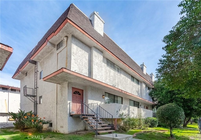 view of front of property with stucco siding and a chimney