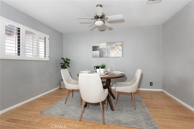 dining room featuring wood finished floors, baseboards, and ceiling fan