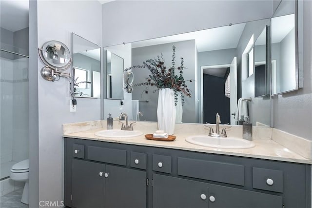 full bathroom with toilet, tiled shower, and double vanity