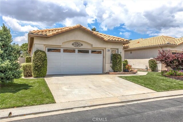 684 Big Spring Dr, Banning, CA 92220 - mediterranean / spanish-style house featuring a garage, concrete driveway, a front lawn, and stucco siding