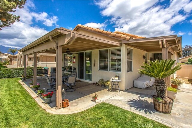 684 Big Spring Dr, Banning, CA 92220 - back of house with a tile roof, stucco siding, a ceiling fan, and a patio