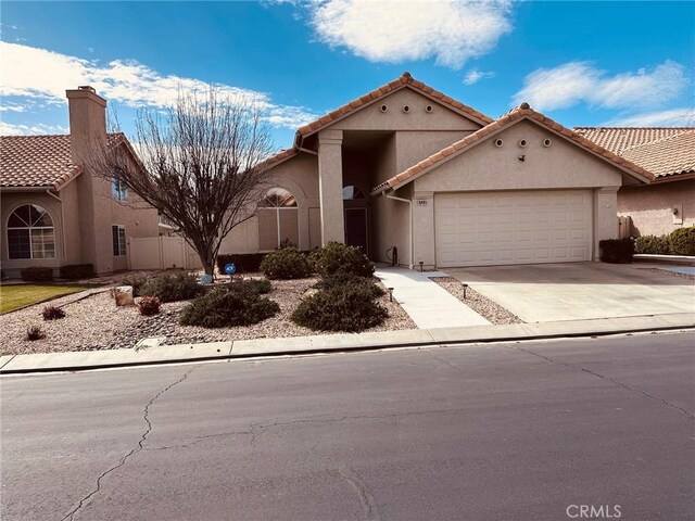 684 Big Spring Dr, Banning, CA 92220 - mediterranean / spanish-style home with stucco siding, a garage, driveway, and a tiled roof