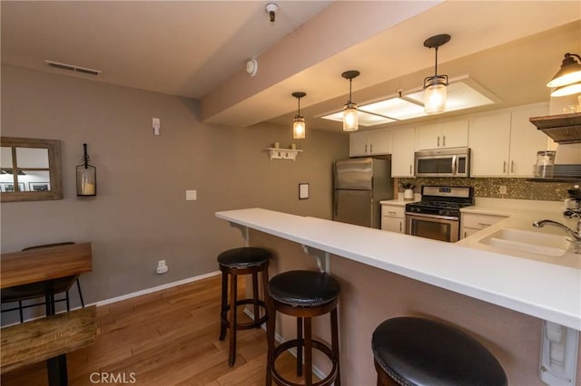 41764 Brownie Ln Unit 5, Big Bear Lake, CA 92315 - kitchen with appliances with stainless steel finishes, a sink, a peninsula, light wood-style floors, and light countertops
