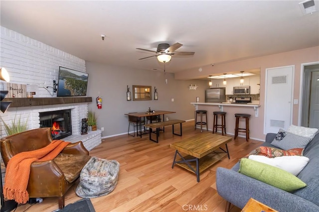 41764 Brownie Ln Unit 5, Big Bear Lake, CA 92315 - living area with wood finished floors, ceiling fan, a fireplace, and baseboards