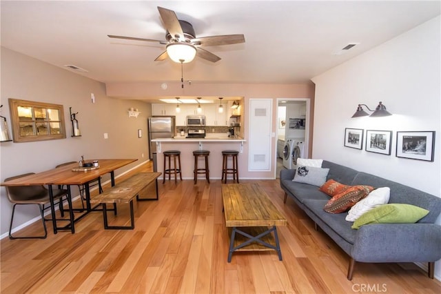 41764 Brownie Ln Unit 5, Big Bear Lake, CA 92315 - living area featuring washer and dryer, a ceiling fan, light wood-type flooring, and baseboards
