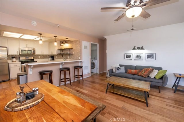 41764 Brownie Ln Unit 5, Big Bear Lake, CA 92315 - living area with washer / clothes dryer, light wood-type flooring, and a ceiling fan