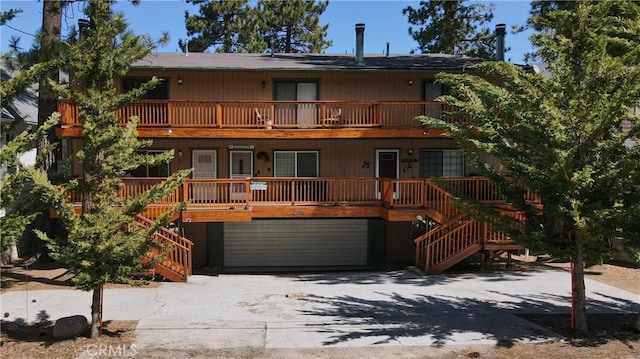 41764 Brownie Ln Unit 5, Big Bear Lake, CA 92315 - back of house featuring stairway, a porch, concrete driveway, and a balcony