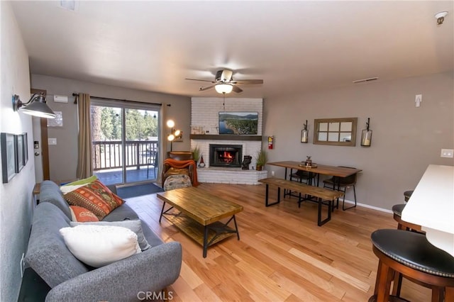 41764 Brownie Ln Unit 5, Big Bear Lake, CA 92315 - living area featuring ceiling fan, light wood-style flooring, a brick fireplace, and baseboards