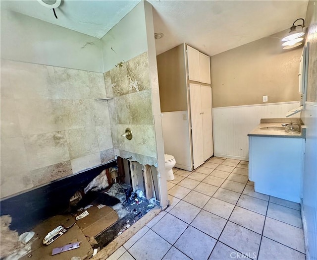 3260 E Westfall Rd, Mariposa, CA 95338 - bathroom featuring tile patterned flooring, tiled shower, toilet, a wainscoted wall, and vanity