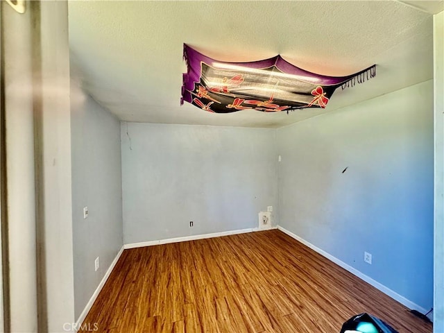 3260 E Westfall Rd, Mariposa, CA 95338 - unfurnished room with wood finished floors, baseboards, and a textured ceiling