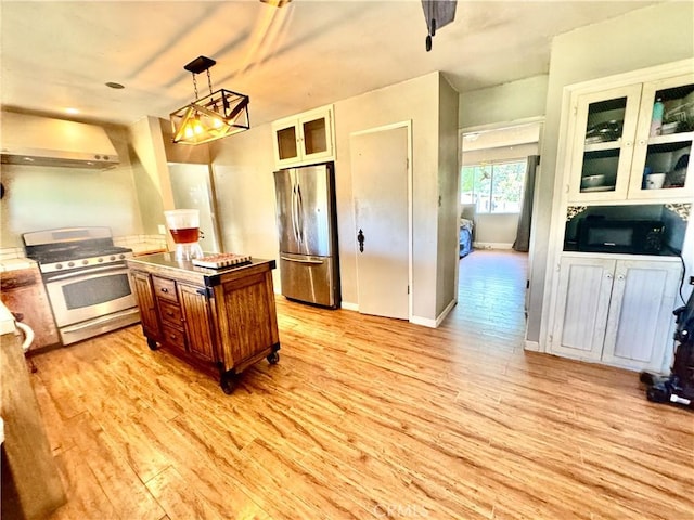 3260 E Westfall Rd, Mariposa, CA 95338 - kitchen with appliances with stainless steel finishes, wall chimney range hood, brown cabinets, and light wood-style floors