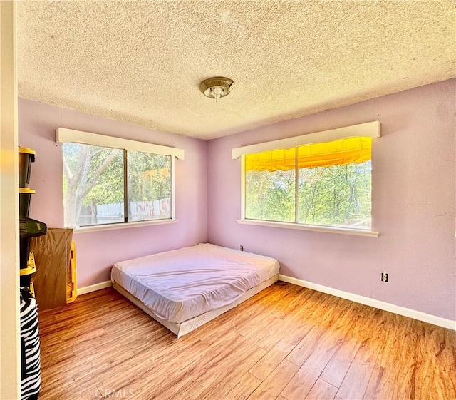 3260 E Westfall Rd, Mariposa, CA 95338 - bedroom featuring wood finished floors, baseboards, and a textured ceiling