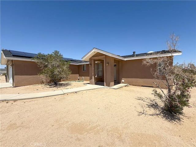74804 Amboy Rd Unit 29, Palms, CA 92277 - view of front of home featuring stucco siding and roof mounted solar panels