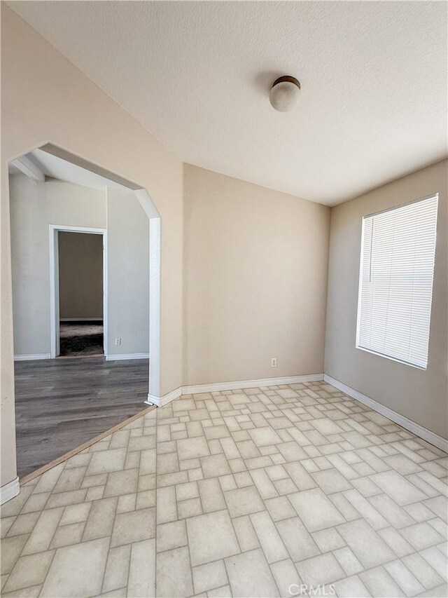 74804 Amboy Rd Unit 29, Palms, CA 92277 - spare room with baseboards, arched walkways, and brick patterned floors