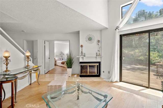 3040 La Paz Ln Unit B, Diamond Bar, CA 91765 - living area with a fireplace with flush hearth, light wood-type flooring, healthy amount of natural light, a textured ceiling, and baseboards