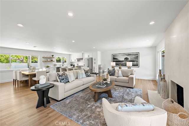 living area with recessed lighting, light wood-style flooring, and baseboards