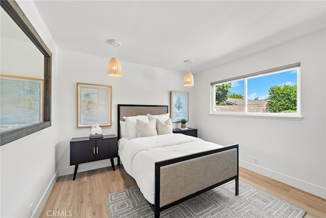 bedroom with wood finished floors and baseboards