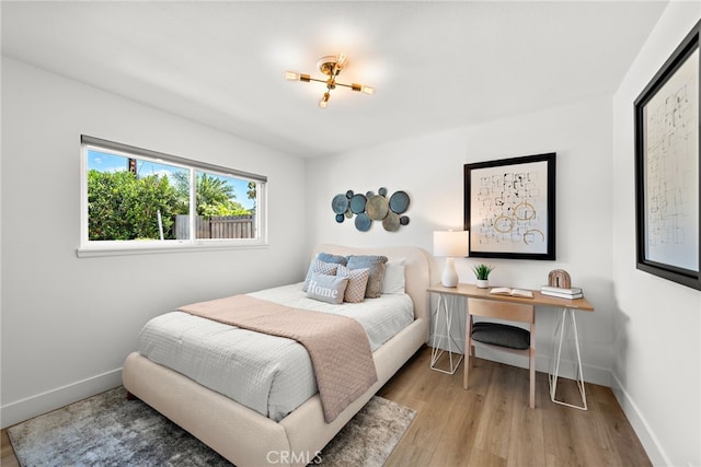 bedroom featuring wood finished floors and baseboards