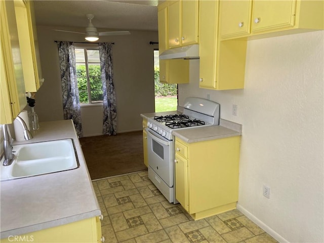 17628 Kornblum Ave, Torrance, CA 90504 - kitchen with white gas range oven, a sink, light countertops, under cabinet range hood, and baseboards