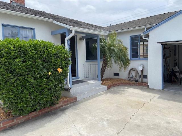 17628 Kornblum Ave, Torrance, CA 90504 - view of exterior entry with stucco siding, roof with shingles, a patio area, and a chimney