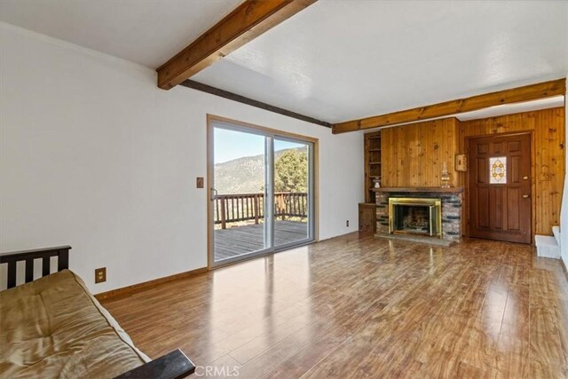 15440 Shasta Way, Pine Mountain Club, CA 93225 - unfurnished living room with beam ceiling, wood finished floors, healthy amount of natural light, a fireplace, and wood walls