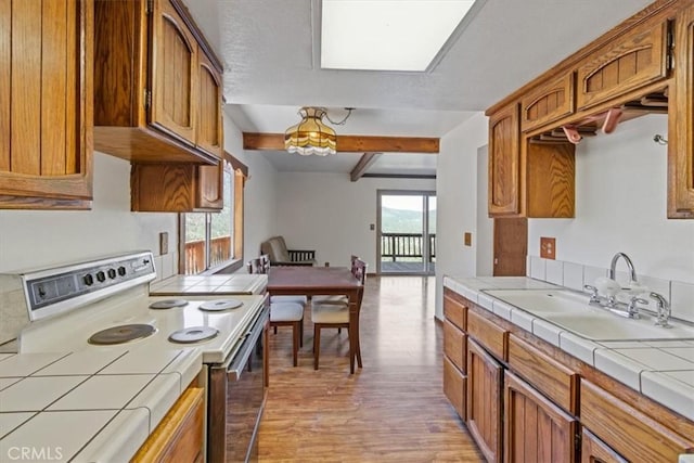 15440 Shasta Way, Pine Mountain Club, CA 93225 - kitchen featuring white electric range oven, tile counters, light wood-style flooring, and beamed ceiling