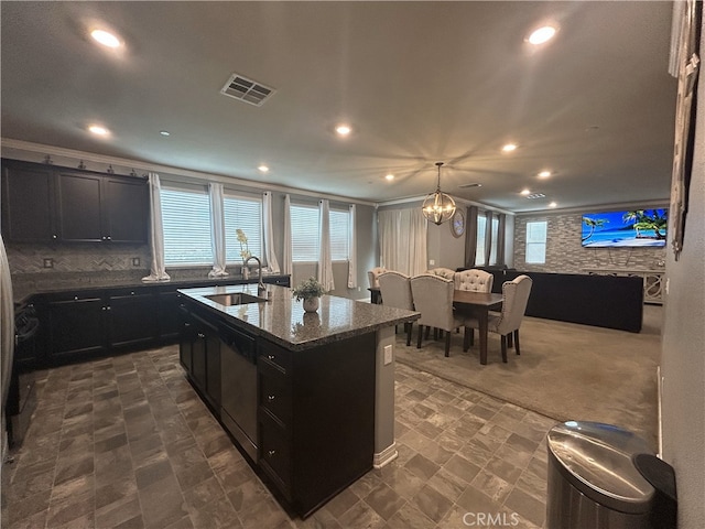 16654 Emerson Ln, Fontana, CA 92336 - kitchen with dark cabinets, dishwashing machine, a center island with sink, dark stone counters, and recessed lighting