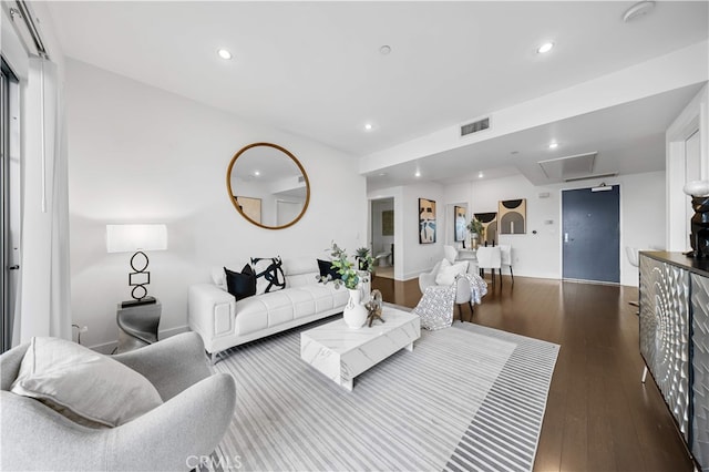 living room with dark wood-style flooring and recessed lighting
