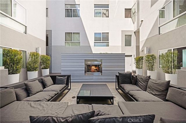 view of patio with an outdoor living space with a fireplace