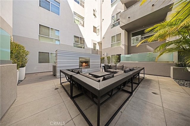 view of patio featuring an outdoor living space with a fireplace
