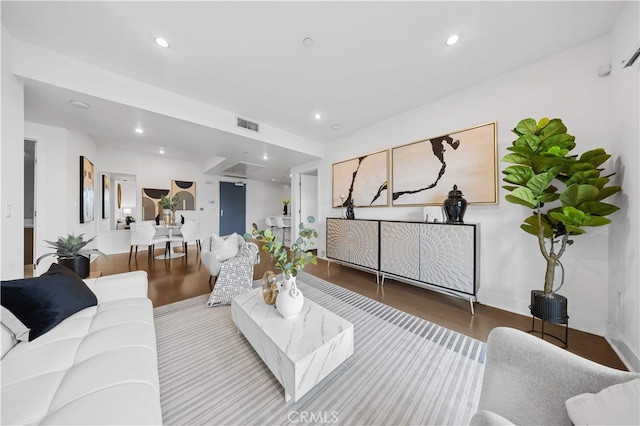 living room featuring wood finished floors, recessed lighting, and baseboards
